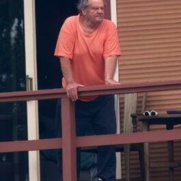 Jack Nicholson în timp ce stă srpjinit de balustrada balconului
