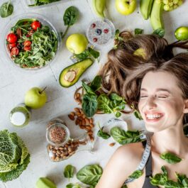 O femeie frumoasă care are fructe și legume pe lângă păr