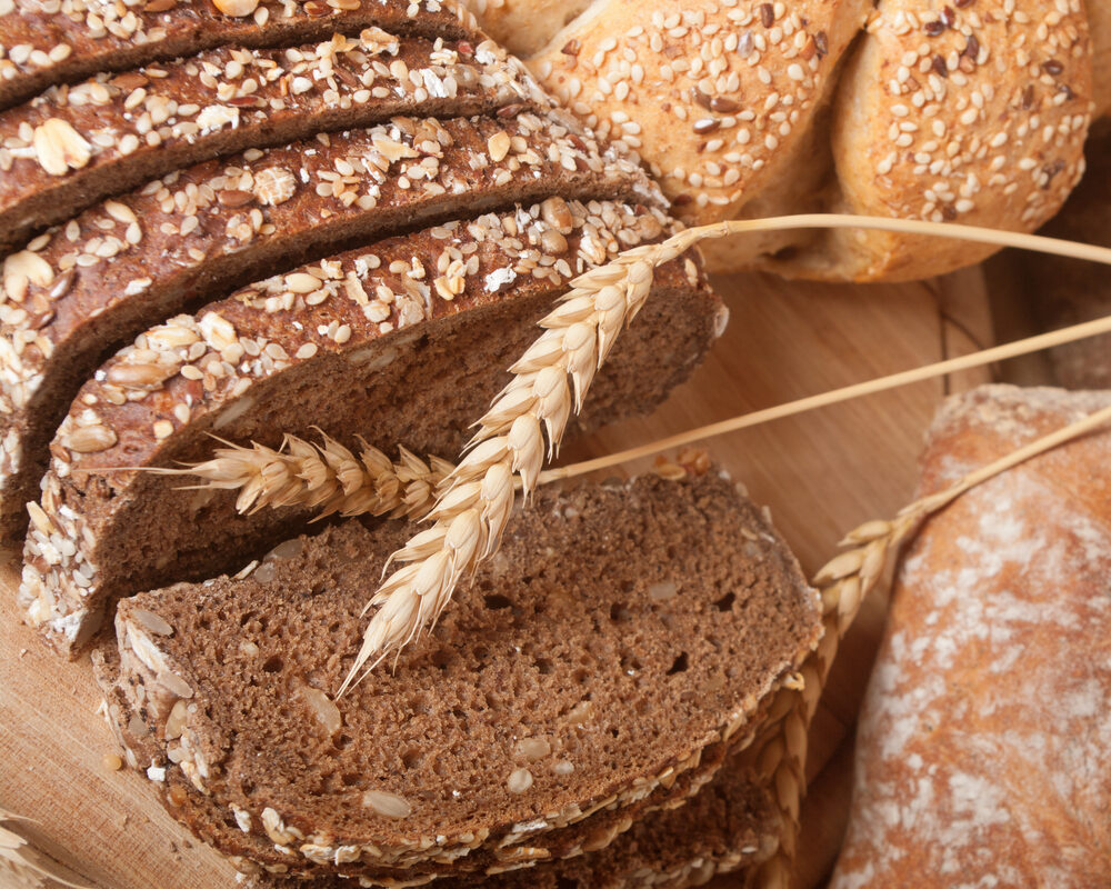 Mai multe tipuri de pâine, aranjate pe un tocător din lemn