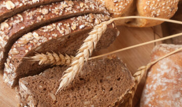 Mai multe tipuri de pâine, aranjate pe un tocător din lemn