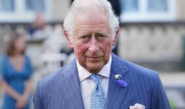Regele Charles îmbrăcat într-un costum albastru în timpul unui eveniment din Londra