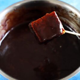 Un cub de prăjitură trecut prin sos de ciocolată
