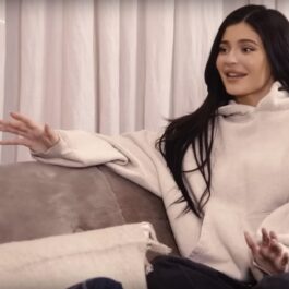 Kylie Jenner, pe o canapea, în timp ce discută cu cineva