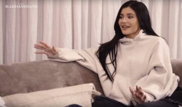 Kylie Jenner, pe o canapea, în timp ce discută cu cineva