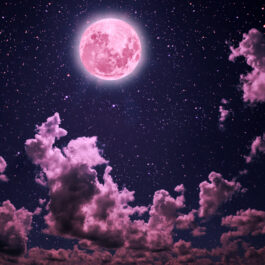 Luna roz pe un cer cu nori și stele