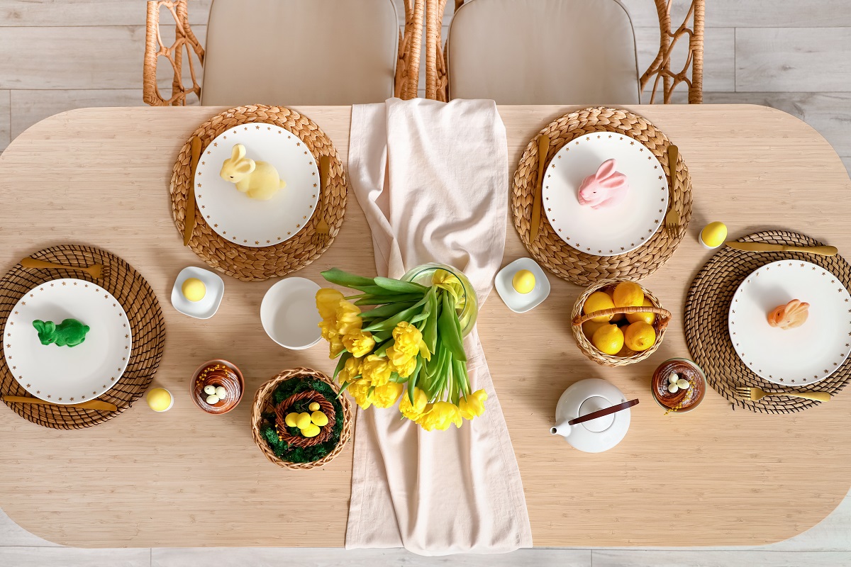 Masa de Paște organizată pe care se află farfurii, tacâmuri și ouă de Paște