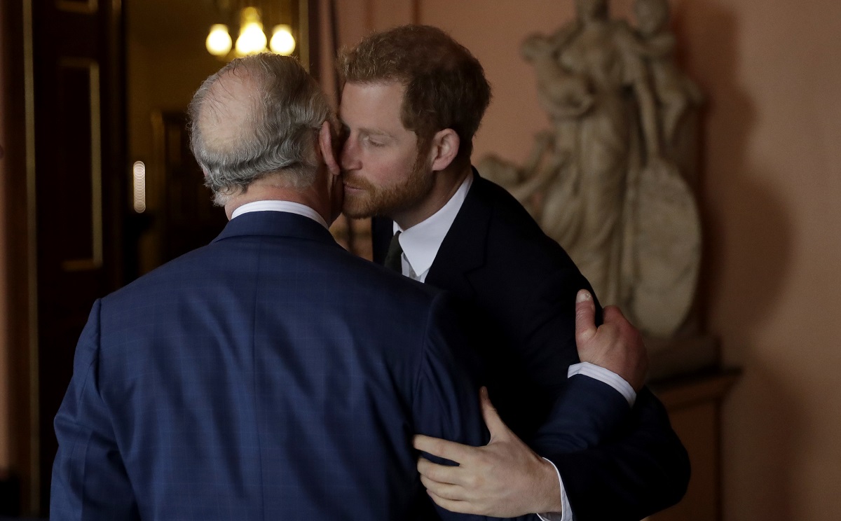 Regele Charles în timp ce se sărută pe obraz cu fiul său, Prințul Harry