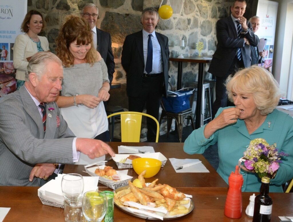 Regele Charles și Regina Camilla în timp ce degustă mai multe preparate la o masă publică