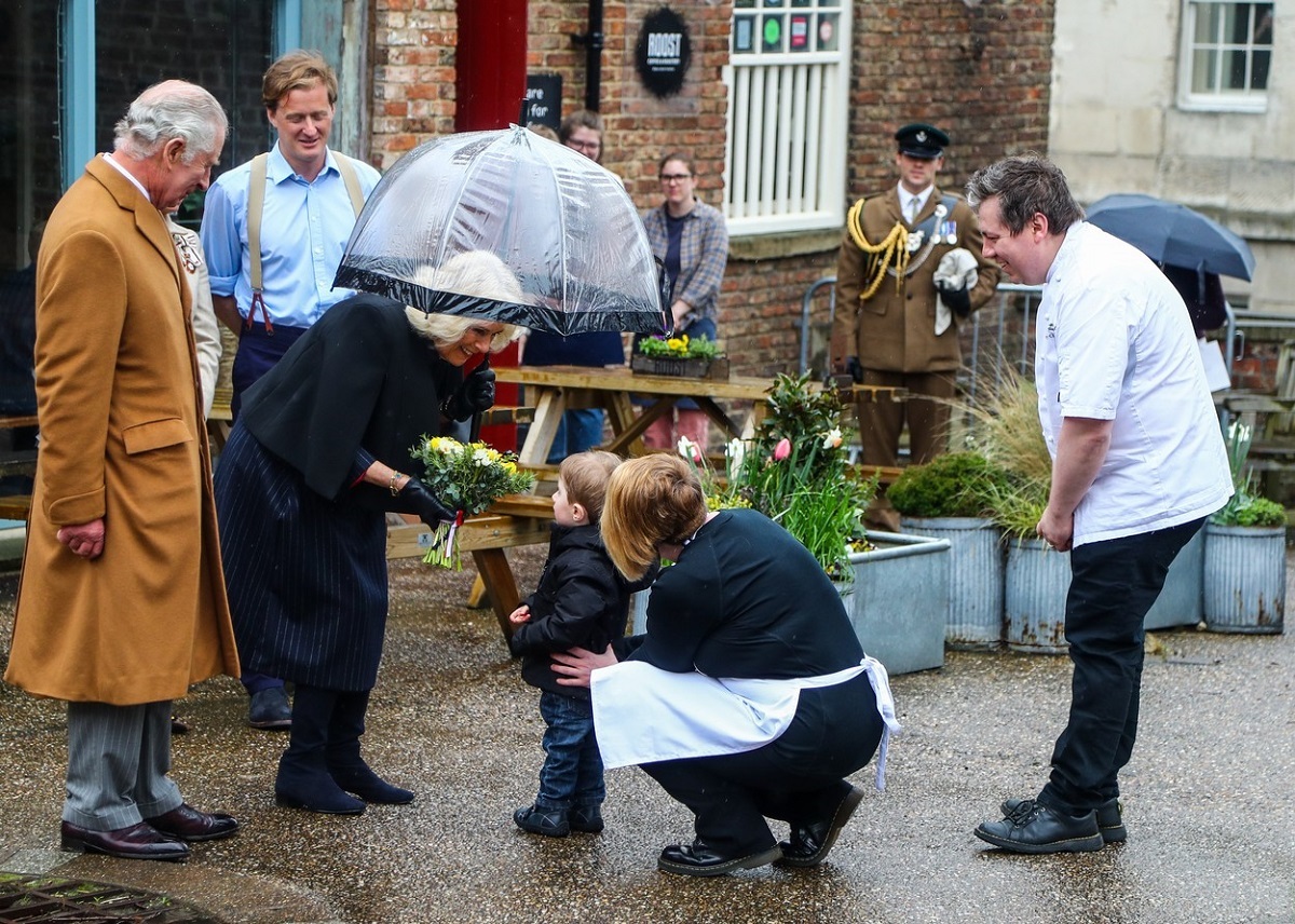 Regina Camilla în timp ce primește un buchet de flori de la un băiețel
