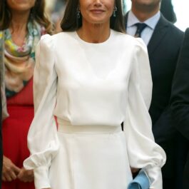 Regina Letizia, într-o rochie albă, la un eveniment, cu un clutch albastru în mână