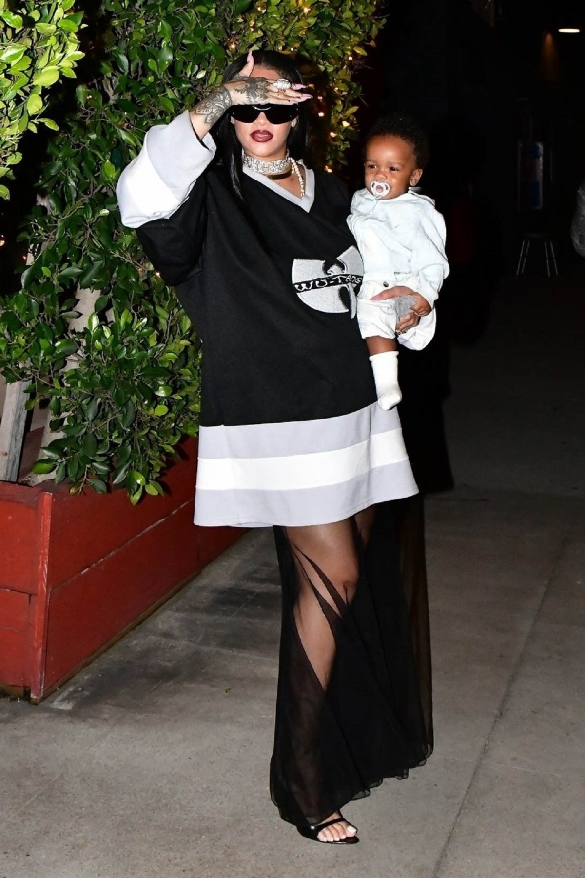 Rihanna în timp ce își ține în brațe fiul și este pozată în fața restaurantului