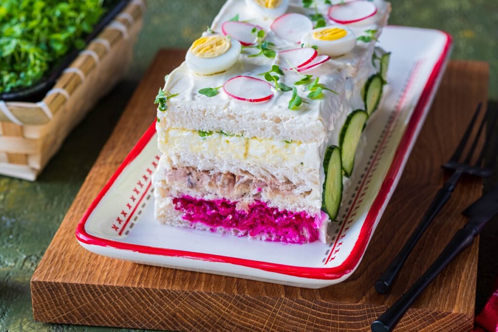 Tort sandviș aperitiv - Smörgåstårta secționat pe un platou alb cu roșu
