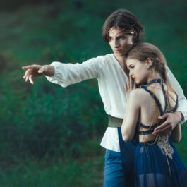 O fată și un băiat se țin îm brațe într-un pădure, îndrăgostiți