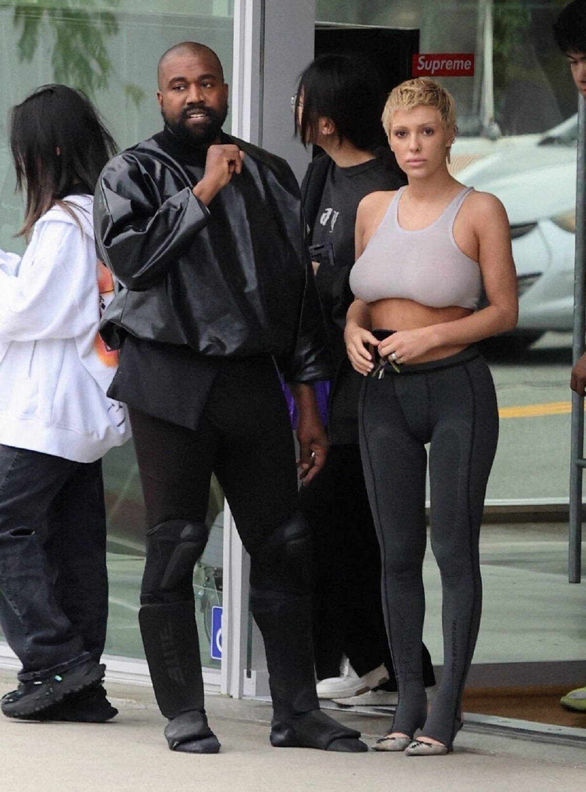 Kanye West într-o ținutp all black alături de Bianca Censori care paortă o bustieră și o pereche de colanți
