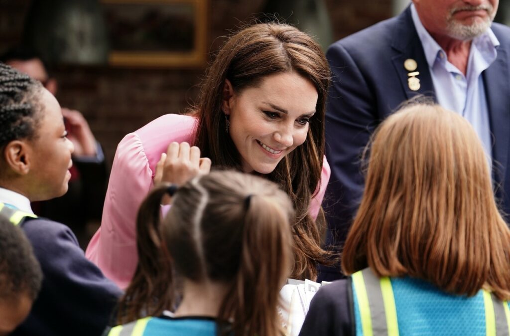 Kate Middleton, aplecată spre copii, în timpul unei expoziții de flori