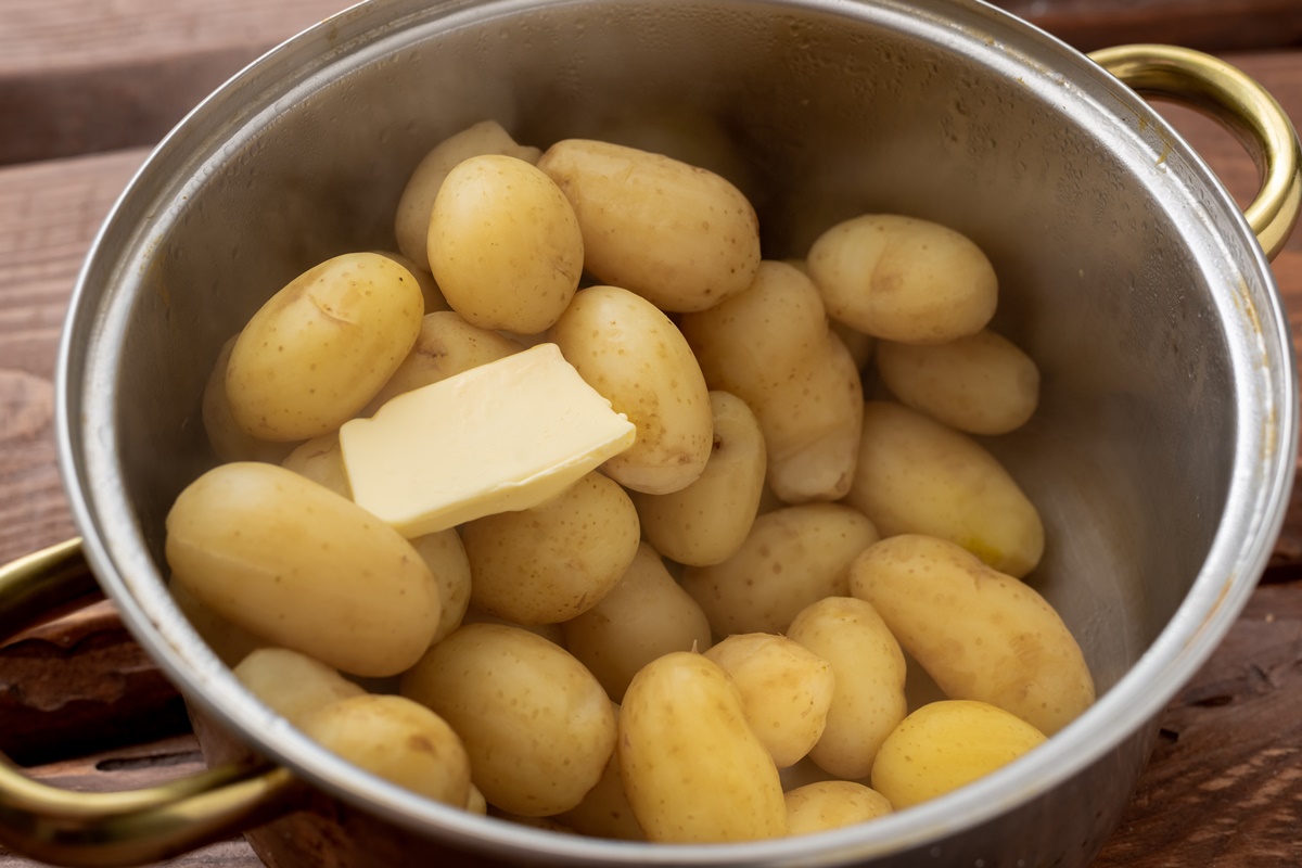 Cartofi fierți în oală cu o bucată de unt