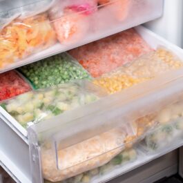 Un congelator în care se află mai multe pungi cu legume congelate