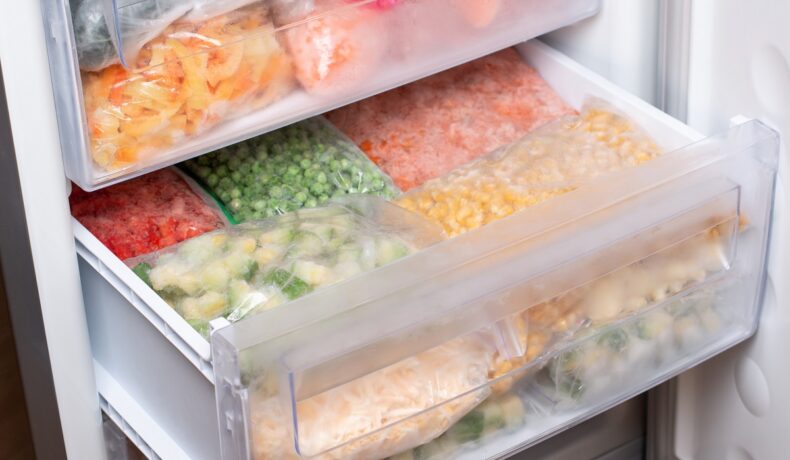 Un congelator în care se află mai multe pungi cu legume congelate