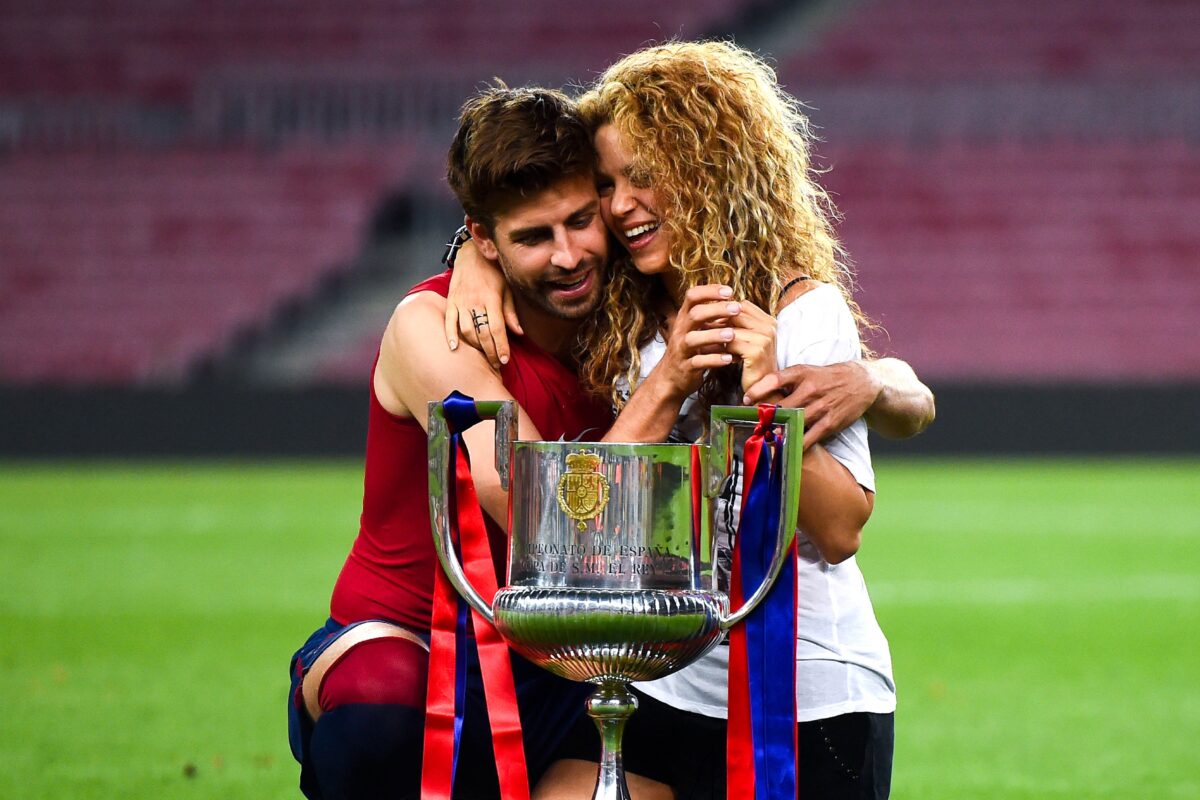 Gerard Pique alături de Shakira pozând alături de un trofeu pe un stadion de fotbal