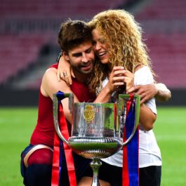 Gerard Pique alături de Shakira pozând alături de un trofeu pe un stadion de fotbal