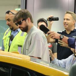 Gerard Pique într-un tricou gri, cu ochelari de soare, în timp ce ia mașina din parcarea aeroportului din Miami