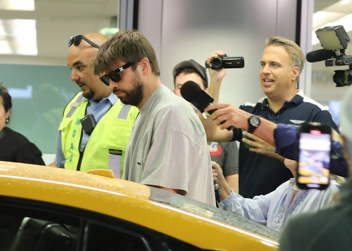 Gerard Pique într-un tricou gri, cu ochelari de soare, în timp ce ia mașina din parcarea aeroportului din Miami