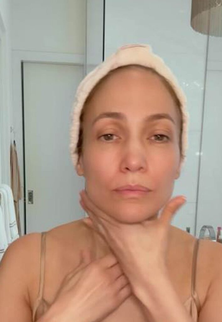 Jennifer Lopez în timp ce își masează gâtul cu loțiune hidratantă