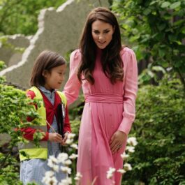Kate Middleton, într-o rochie roz, cu o fetiță, la o expoziție de flori