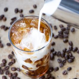 Lapte turnat într-un pahar cu cuburi de cafea înghețată