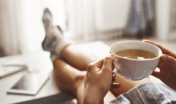 O femeie care își bea cafeaua dimineața