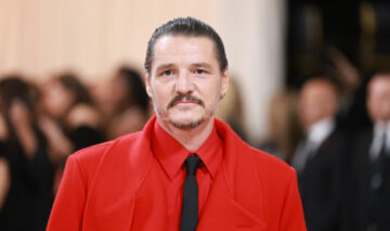 Pedro Pascal, într-un costum roșu, cu o cravată neagră, la Met Gala 2023