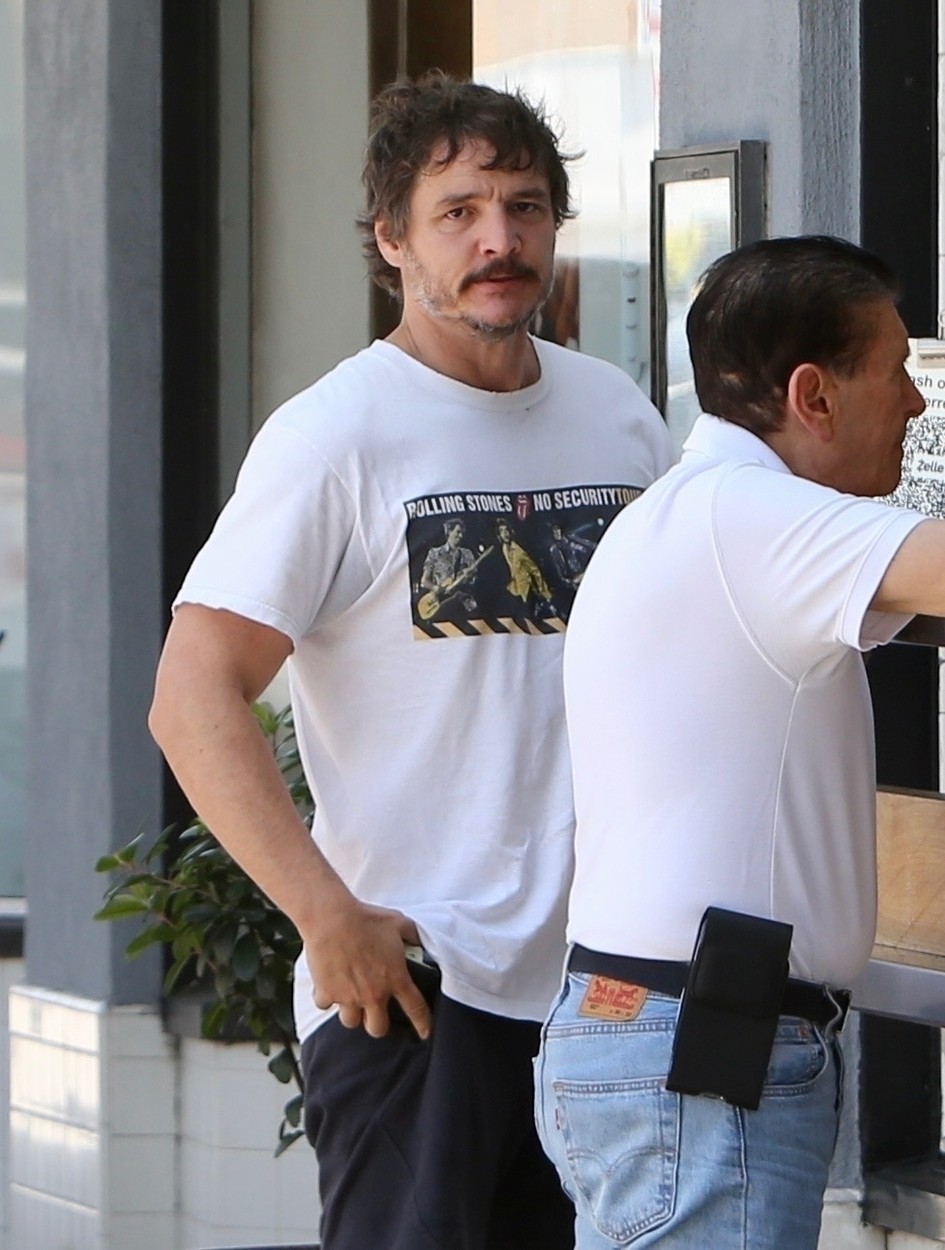 Pedro Pascal, la un bancomat în Los Angeles, într-un tricou alb și pantaloni scurți