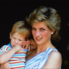 Prințesa Diana în timp ce-l ține în brațe pe Priințul Harry într-o fotografie din 1986