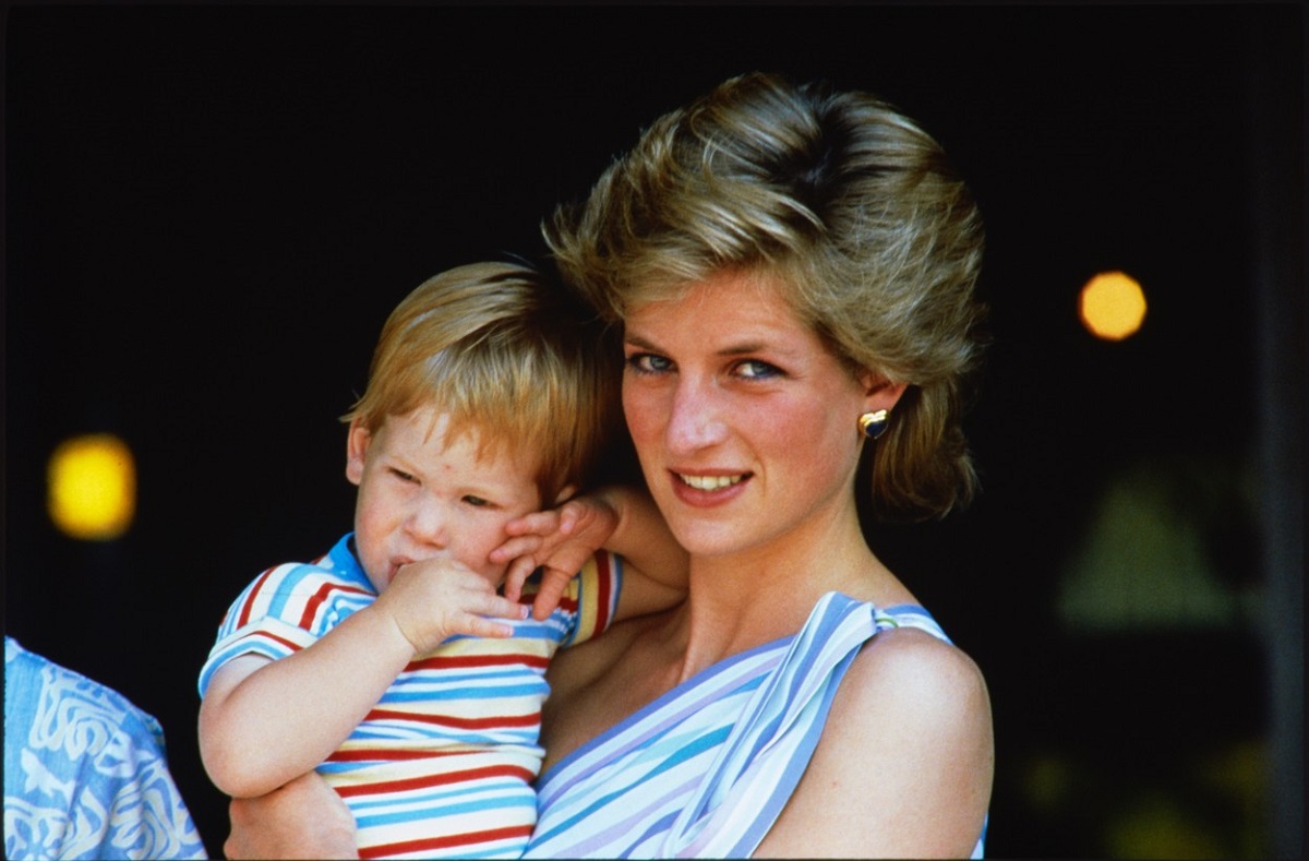 Prințesa Diana în timp ce-l ține în brațe pe Priințul Harry într-o fotografie din 1986