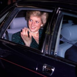 Prințesa Diana într-o mașină în timp ce face cu mâna oamenilor