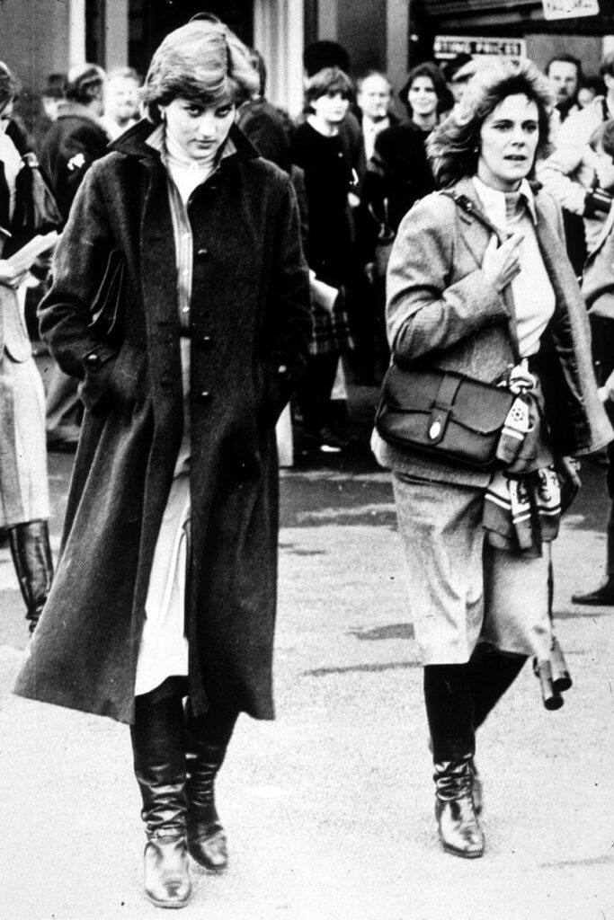 Prințesa Diana alături de Camilla Parker Bowles în timp ce merg să urmărească o competiție sportivă la care participă și Prințul Charles, în anul 1980