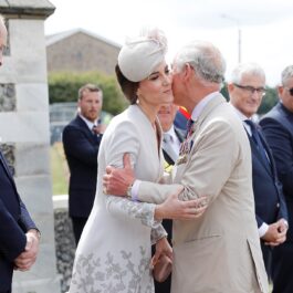 Kate Middleton și Regele Charles în timp ce se sărută pe obraz