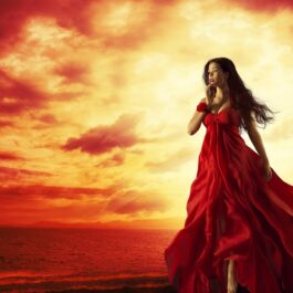 O femeie frumoasă, într-o rochie roșie, care ilustrează una dintre cele trei zodii care pierd bani în luna iunie 2023