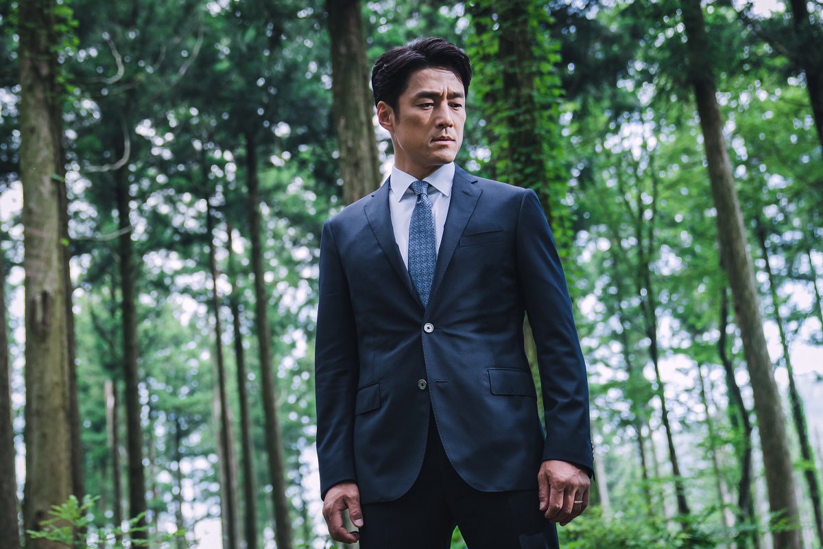 Ji Jin-hee apare într-un costum în timpul filmărilor pentru The Road: The Tragedy of One