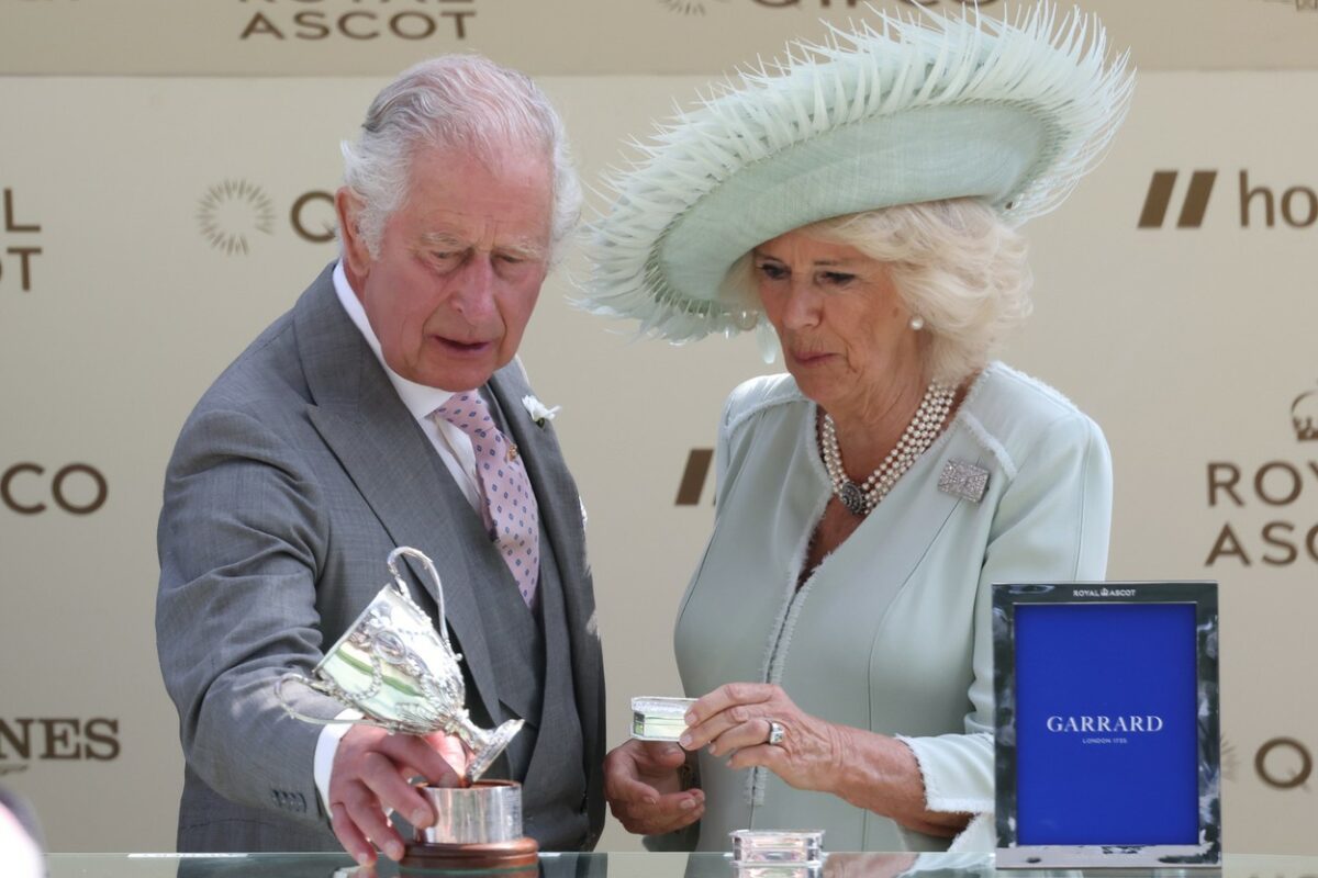 Regele Charles, într-un costum gri, alături de Regina Camilla, pe scena de la Royal Ascot