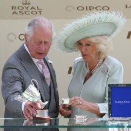 Regele Charles, într-un costum gri, alături de Regina Camilla, pe scena de la Royal Ascot