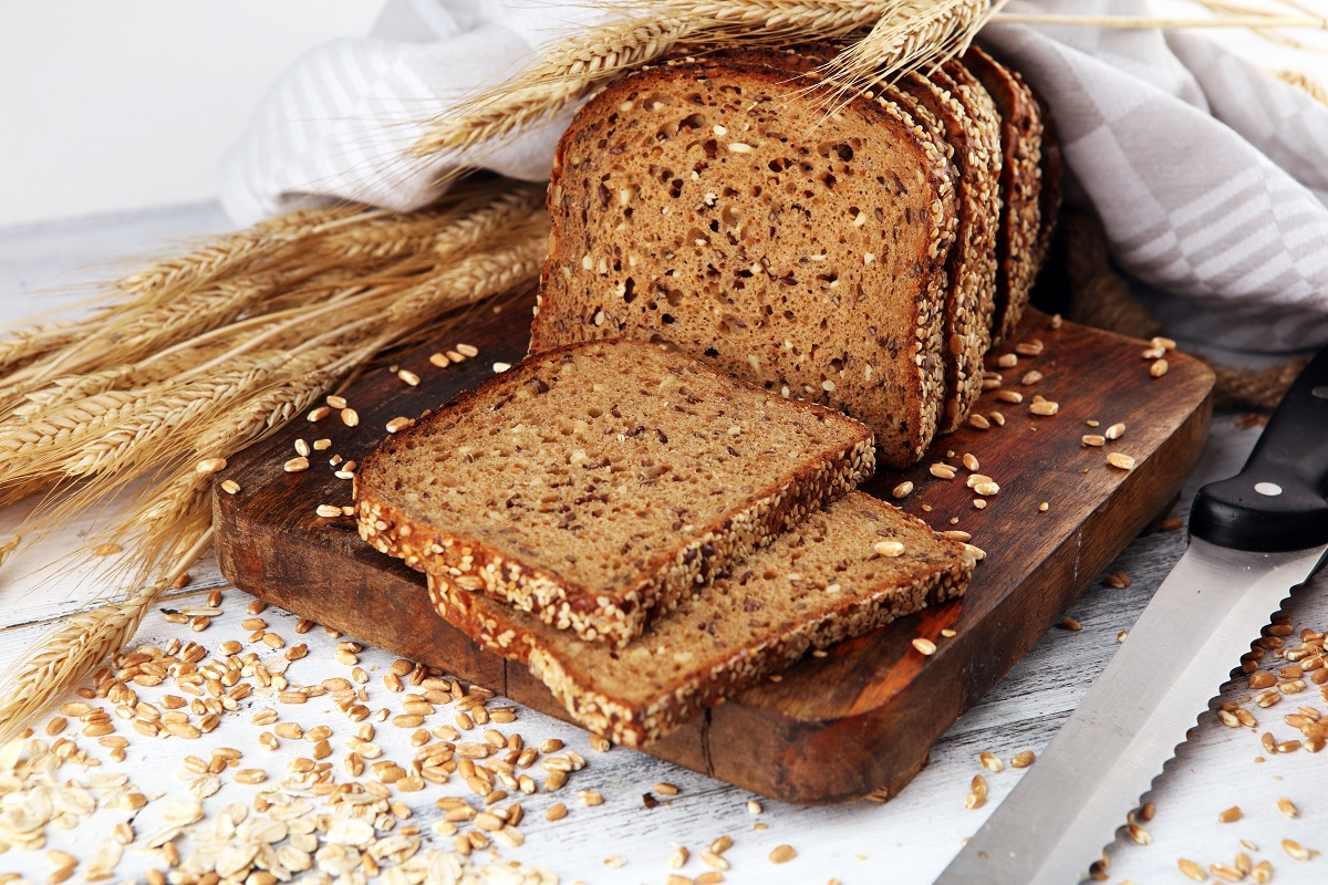 O pâine feliată pe un tocător de lemn pentru a ilustra de ce nu e recomandat să ții pâinea în frigider