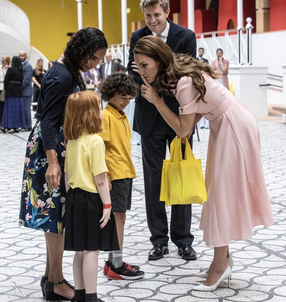 Kate Middleton în timp ce se apleacă pentru a vorbi cu un grup de copii