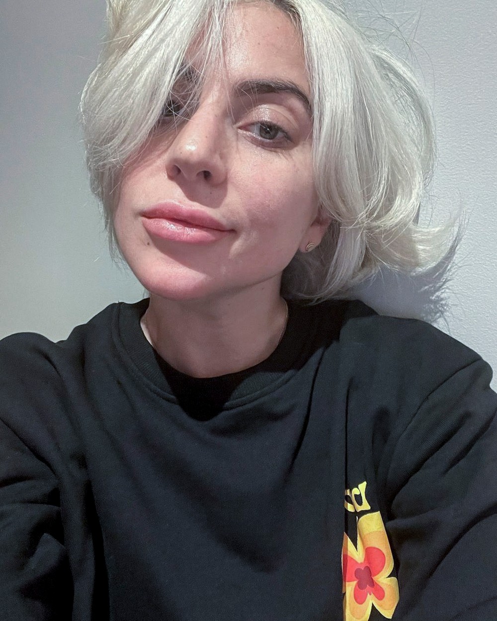 Lady Gaga, într-o bluză neagră, cu părul coafat, nemachiată