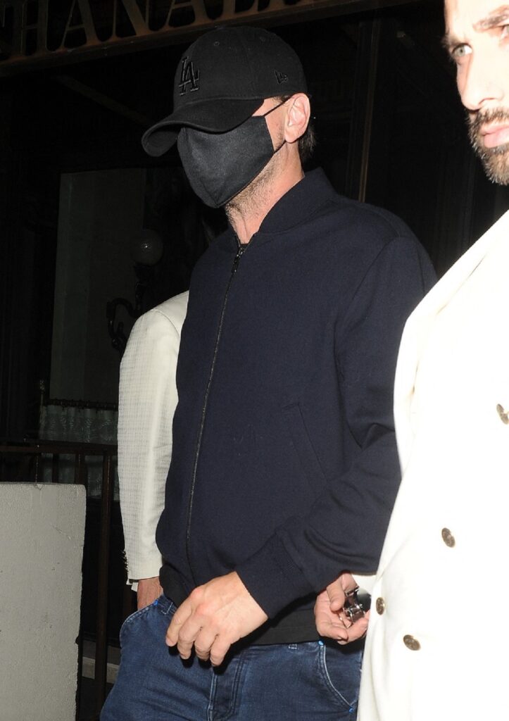 Leonardo DiCaprio purtând mască de protecție și șapcă neagră pentru a se feri de fotografi