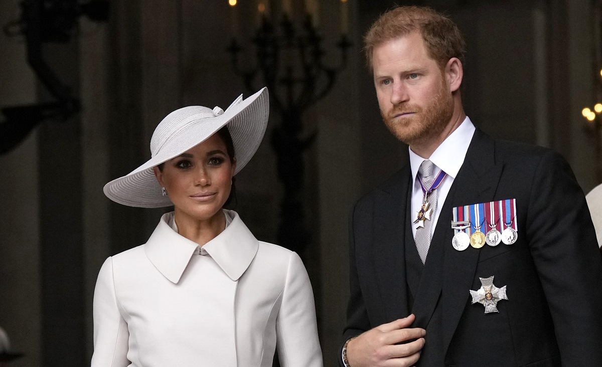 Meghan Markle într-un costum alb și Prințul Harry la un costum negru în timp ce participă la Ziua Recunoștinței în Londra în 2022