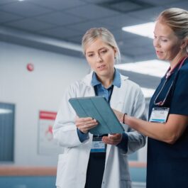 Două doctorițe care stau pe holul unui spital și se consultă despre cât de mult este recomandat să mergi zilnic pe jos pentru a-ți menține inima sănătoasă