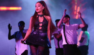 Ariana Grande, într-o ținută neagră de scenă, în timpul unui concert