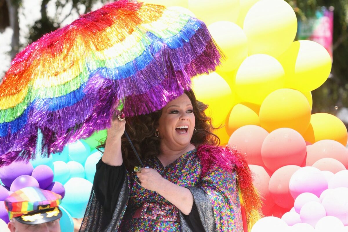 Melissa McCarthy, pe stradă, cu o umbreă curcubeu, la o paradă LGBTQ