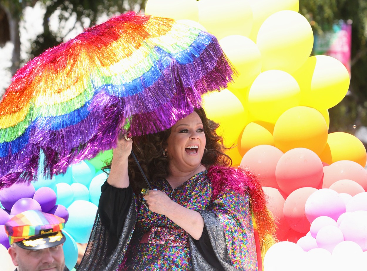 Melissa McCarthy, pe stradă, cu o umbreă curcubeu, la o paradă LGBTQ